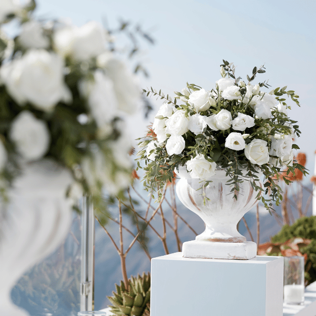 A pristine white vase adorned with delicate white flowers, capturing the elegance of Erossea Villa Santorini Wedding