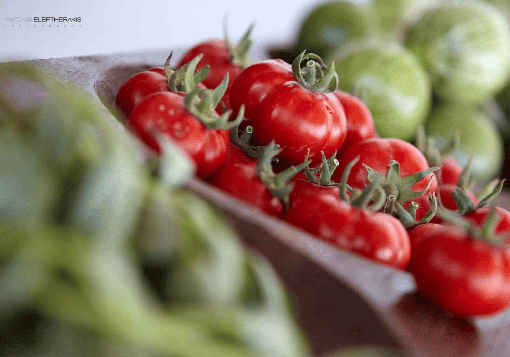 Vibrant bowls of tomatoes and green vegetables, highlighting the culinary offerings of Erossea Villa Santorini
