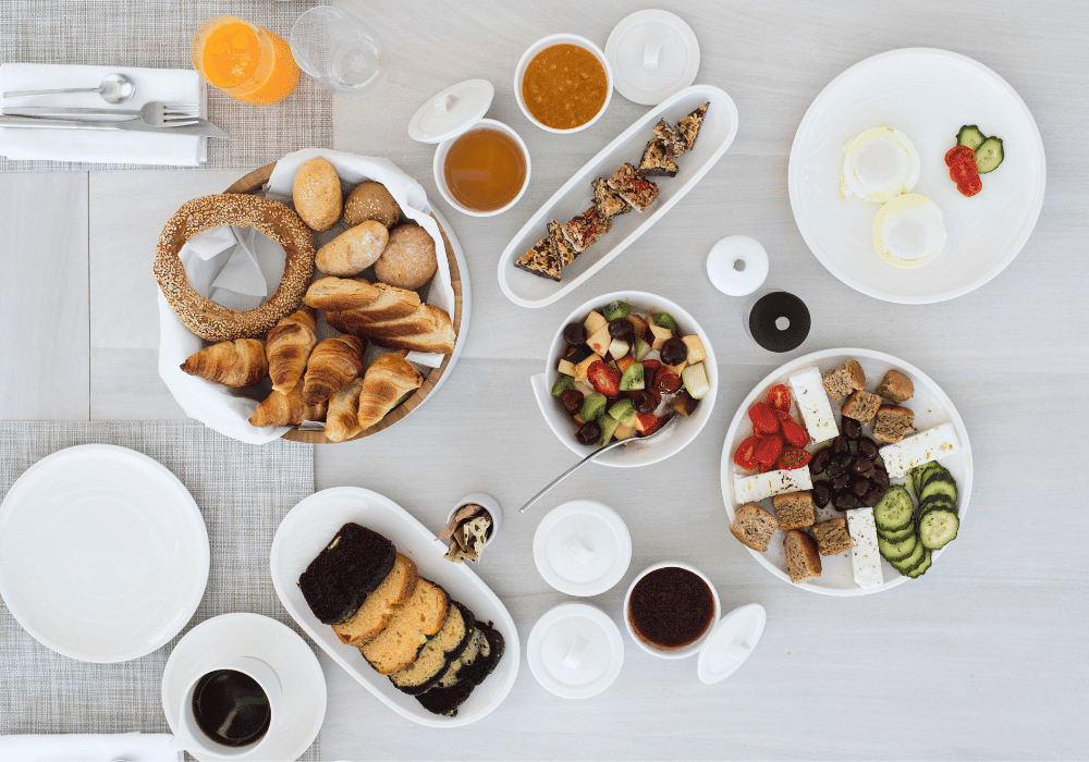 A beautifully arranged table at Erossea Villa Santorini, featuring an array of breakfast plates filled with food and drinks