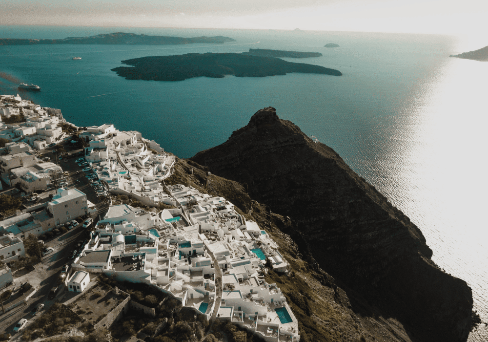 Aerial view of  Santorini, showcasing Erossea Villa and the stunning blue waters of the Aegean Sea