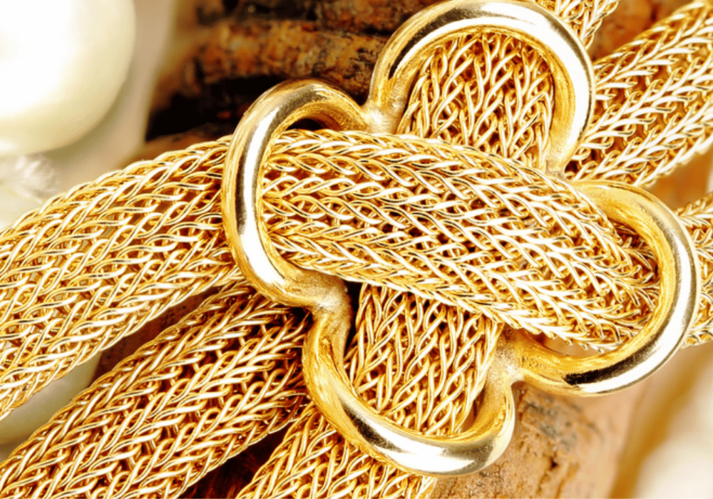 A close-up view of a gold jewelry piece featuring an elegant pearl clasp, showcased in Santorini for shopping