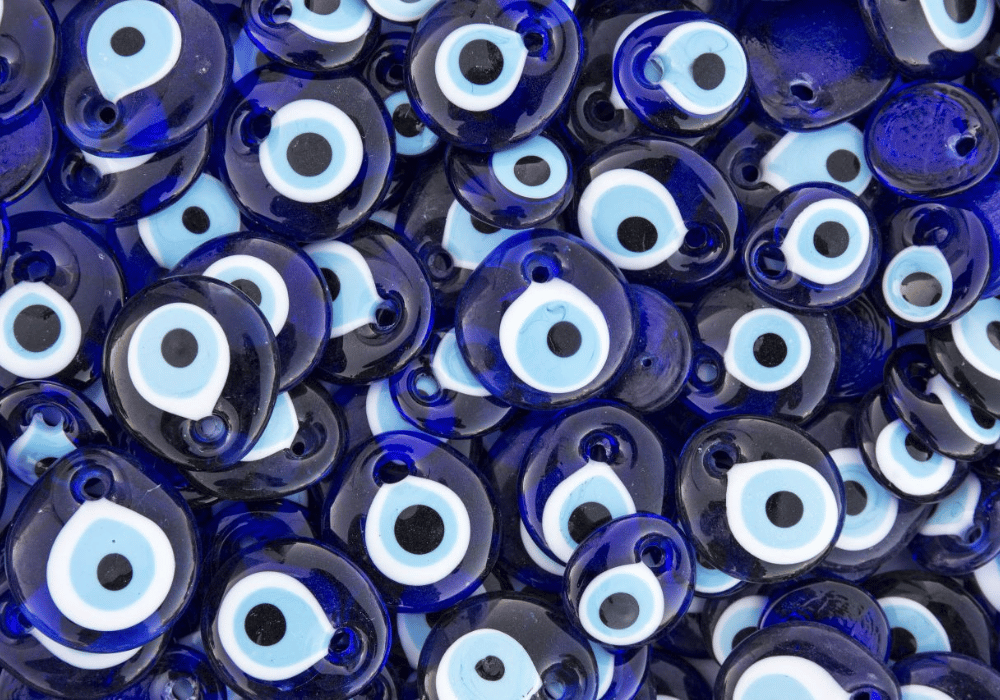 A collection of blue and white evil eye beads displayed for Shopping in Santorini, symbolizing protection and good luck.